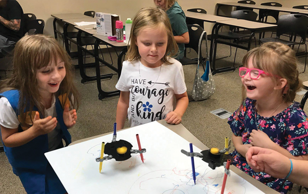 Daisy Girl Scouts playing with robots