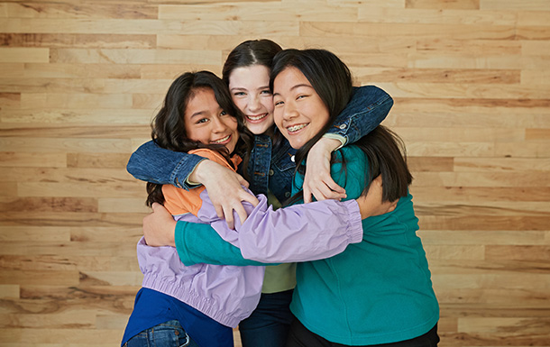 Girl Scout friends hugging and laughing