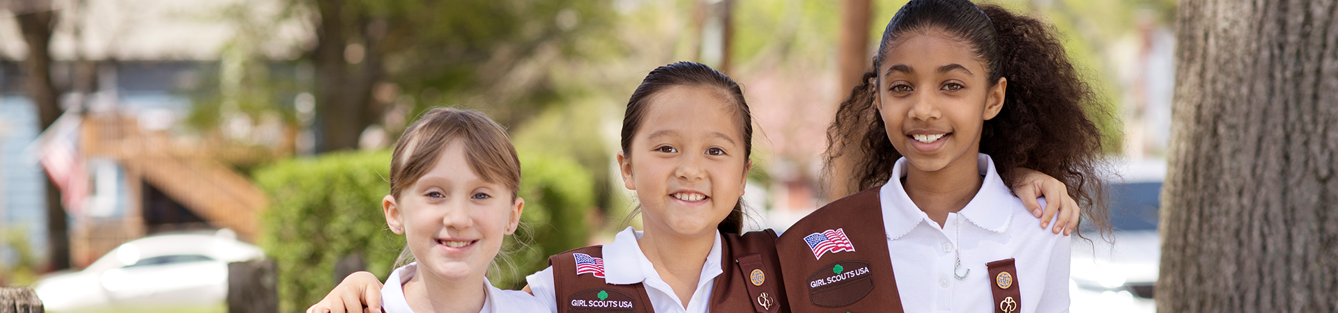  Girl Scout Brownies with their arms around each other 