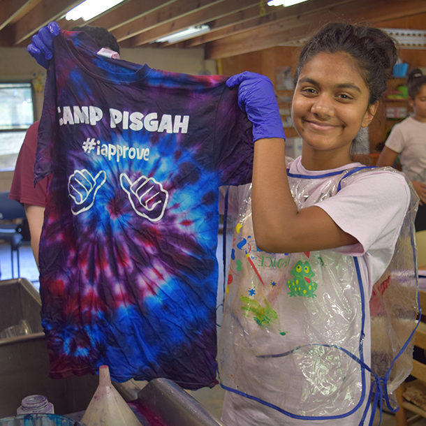 girl making tie dye shirt wearing gloves and apron