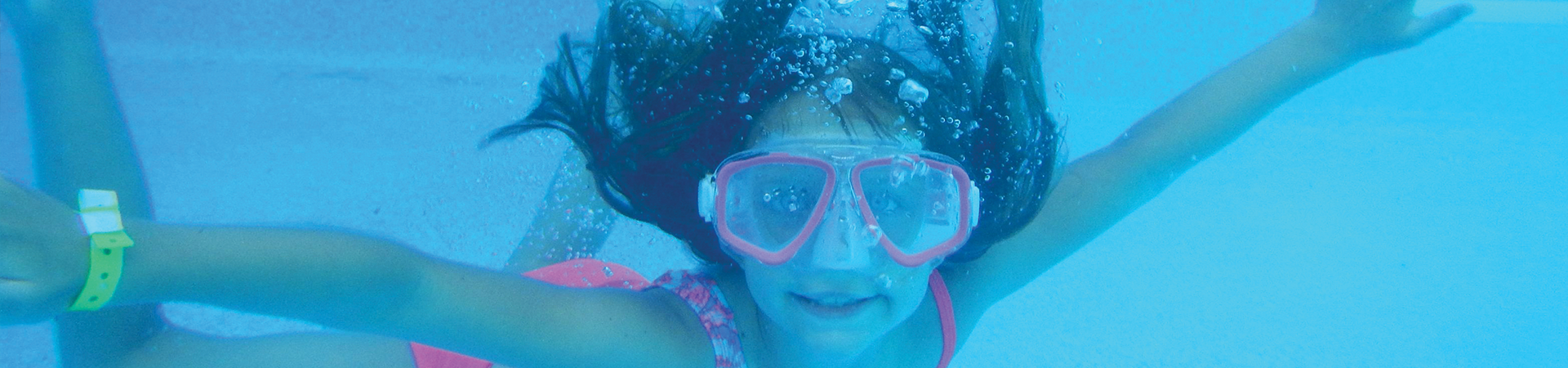  girl underwater wearing pink goggles 